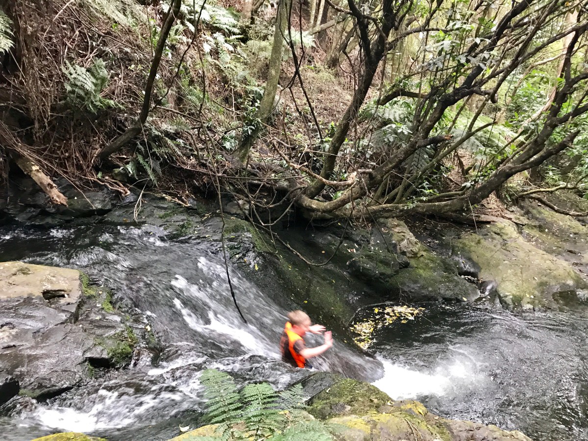 boy sliding down a waterfall