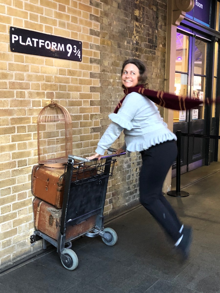 woman with luggage trolley on platform 9 3/4