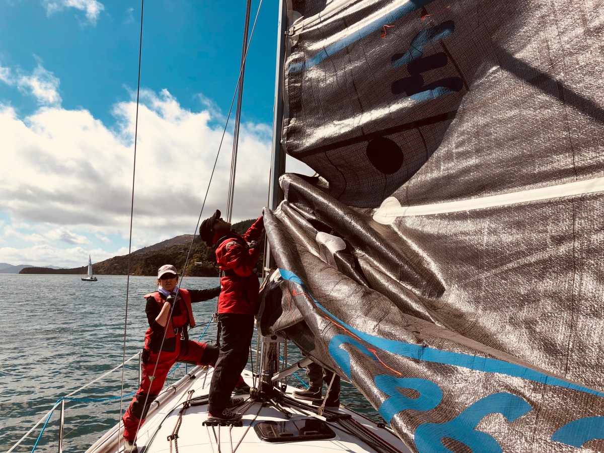 women hoisting sails on Elliott 1050 yacht