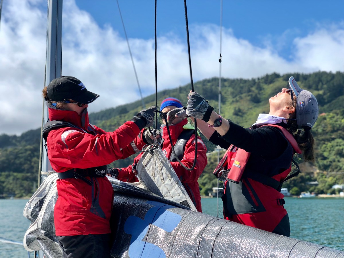 women hoisting sail on Elliott 1050 yacht
