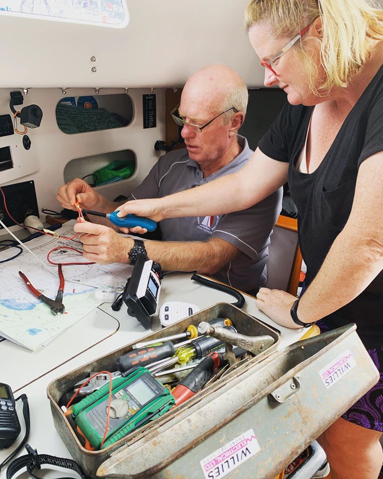 Man and woman doing electrical repairs on board a yacht